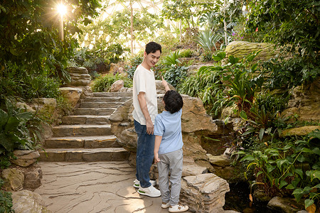 带孩子的父亲父亲带着儿子在植物园参观背景