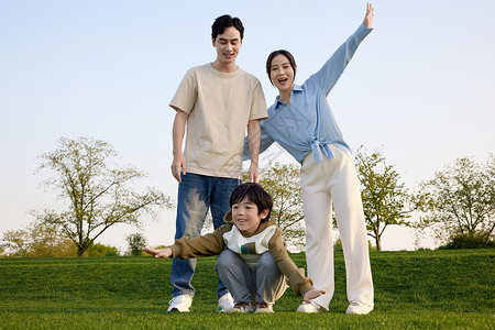 一家人在草坪上张开双臂高清图片