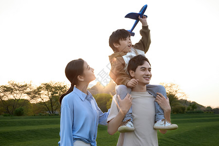 一家人在草坪上玩飞机玩具高清图片