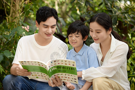 儿童启蒙探索一家人在植物园坐着看植物科普书背景