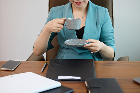 上班的女人女白领在办公室喝咖啡特写背景