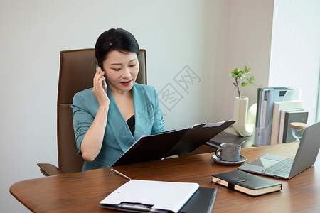 电脑前的女白领坐在电脑前打电话背景