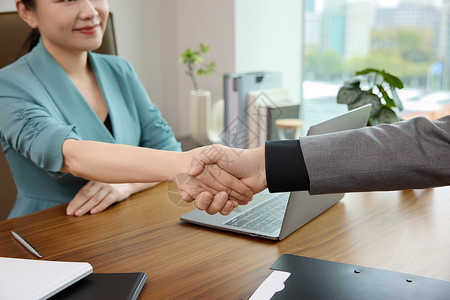 企业运营管理两位白领在办公室达成合作握手特写背景