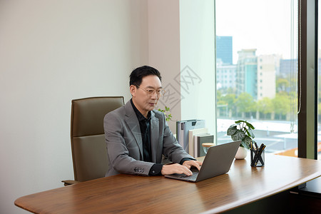 在办公室对着电脑工作的男白领形象背景