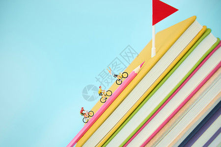 创意学生彩色书籍上骑行的创意微距小人背景