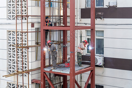 湖北黄石市旧小区改造中工人在安装电梯时的施工场景图片素材