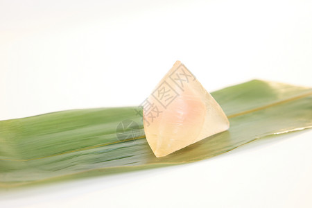 传统餐饮一片粽叶上的粉色水晶粽子背景