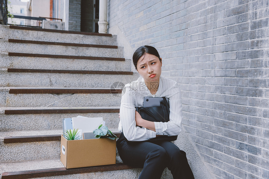 坐在楼梯上因失业而伤心的女职员