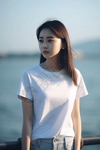 白色t恤女一位美丽年轻中国女孩站在海边背景