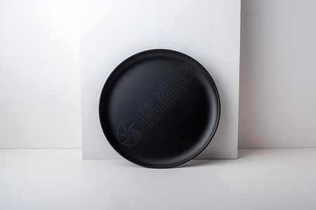 白色石膏板上的黑色瓷碗高清图片