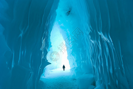 情侣冬天行走在冰洞隧道中的游客设计图片