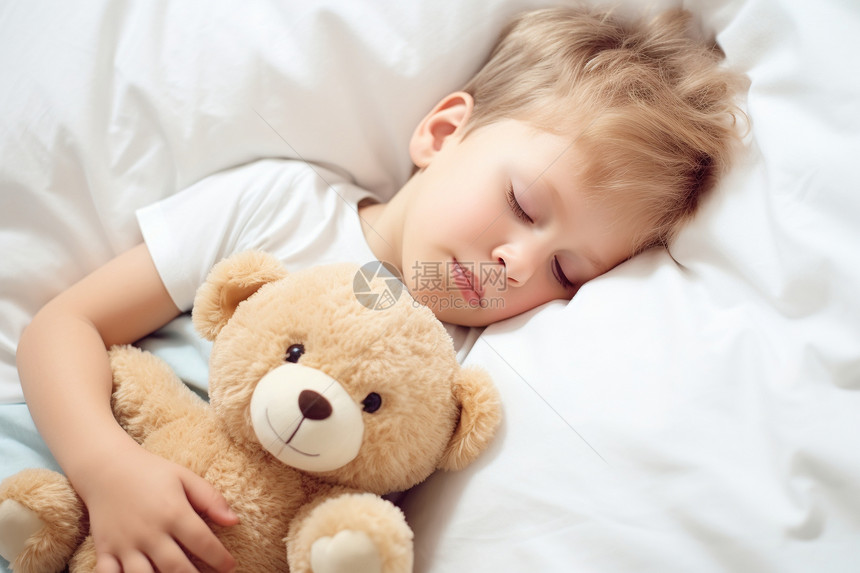抱着玩具熊睡觉的男孩图片
