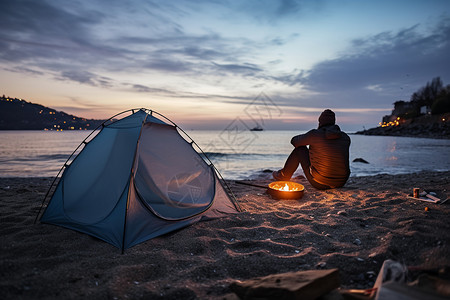 海滩在晚上男人孤独的在海边露营背景