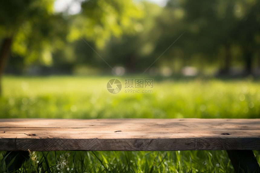 公园草坪上的模糊木桌背景图片