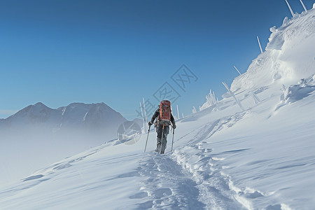 在雪山冰川上行走的冒险家高清图片