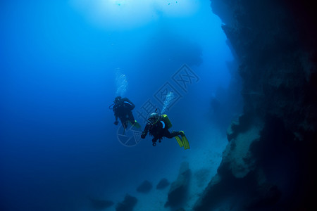深海潜水员在光束照耀下游泳高清图片