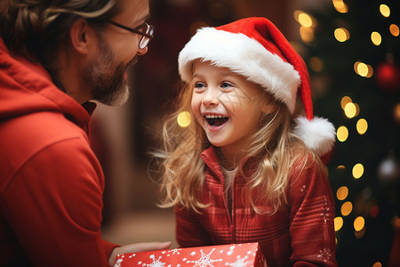 圣诞庆祝中一个小女孩打开礼物的开心一刻高清图片