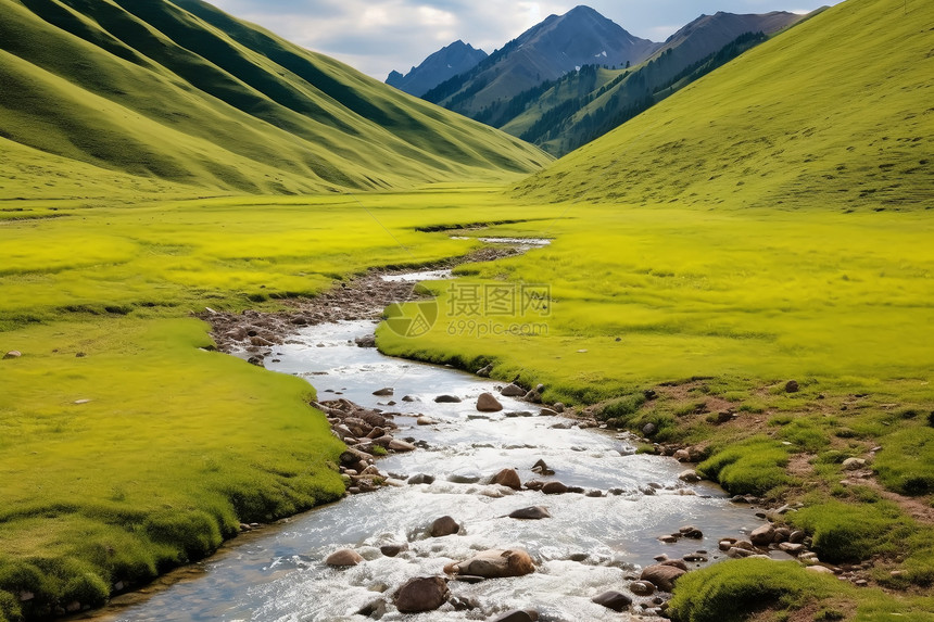 山脉间草地上流过一条小溪图片