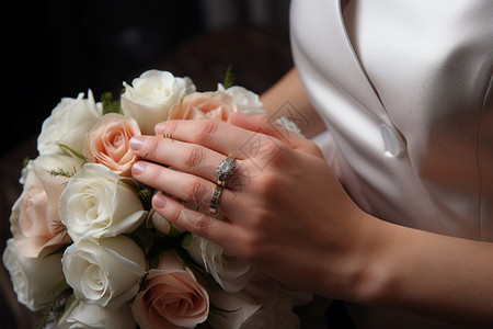新娘把戴着婚戒的手放在捧花上背景图片