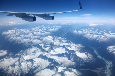 辽阔雪山山脉上空的飞机图片