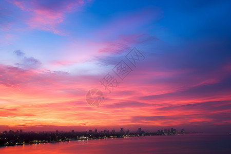 夕阳映照下的水边城市背景图片