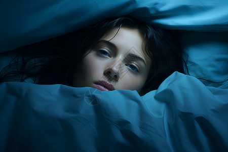 蓝色被子里的失眠女人背景图片