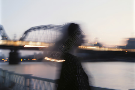 黄昏桥边模糊的女人背景图片