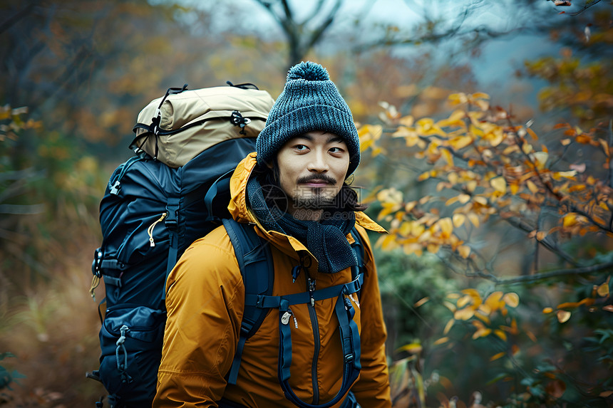 胡须男子在秋天的树林中旅行图片