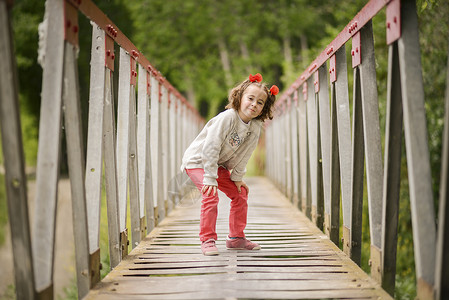 可爱的小女孩乡村桥上玩得很开心图片