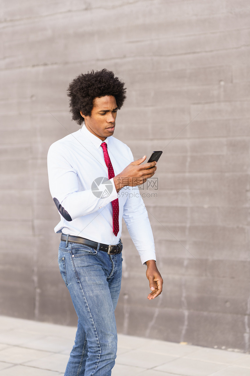 黑人商人用他的智能手机走街上黑人商人办公楼附近用智能手机图片
