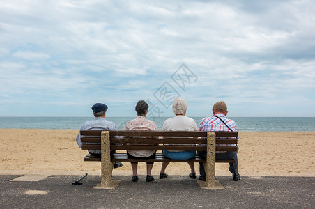 四位匿名老人老夫妇坐海滩长凳上的老年男女的后视镜图片