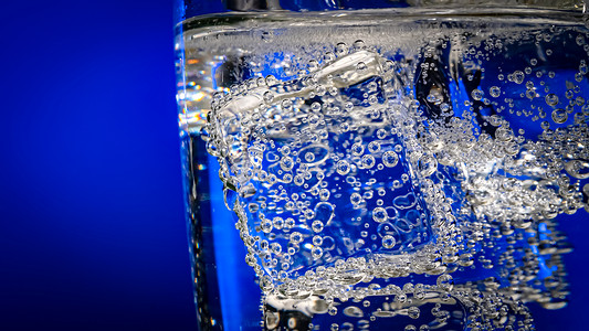 杯深蓝色背景上有冰的水背景图片