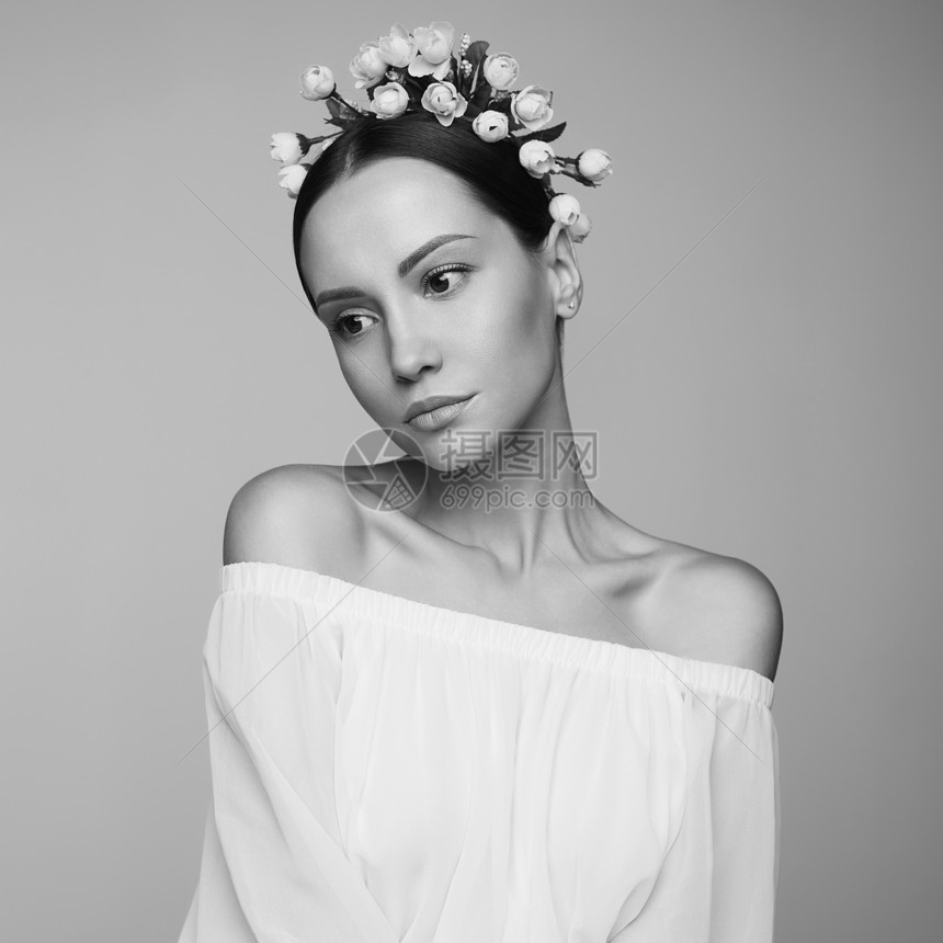 时尚工作室的年轻美女肖像,穿着希腊白色连衣裙,头上戴着鲜花时尚风格图片