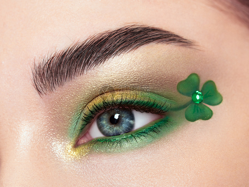 圣帕特里克节照片年轻美丽的女人的眼睛,明亮的绿色阴影富有表现力的眉毛三叶草图案假日化妆图片