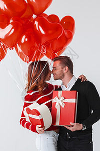 幸福的微笑夫妇着情人节礼物白色背景上的红色气球情人节礼物图片
