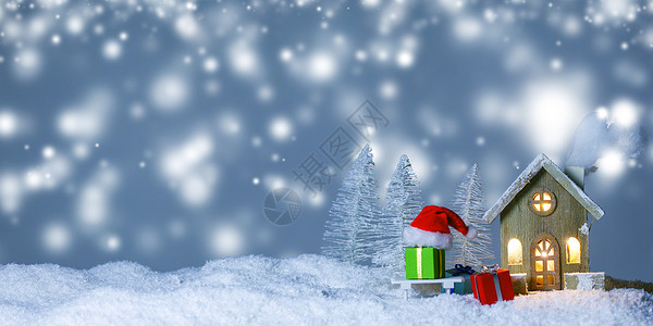 圣诞卡与小发光装饰房子,礼物圣诞老人帽雪橇上的雪上的童话冬天冷杉森林背景下雪新年明信片文本房子圣背景图片