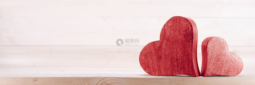 两颗手工制作的红色木刻心轻木背景下情侣关系情人节的两颗木头心图片