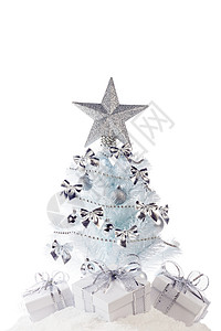 白色圣诞树上有银色的装饰品礼物,白色背景上隔离雪地上圣诞树礼物图片