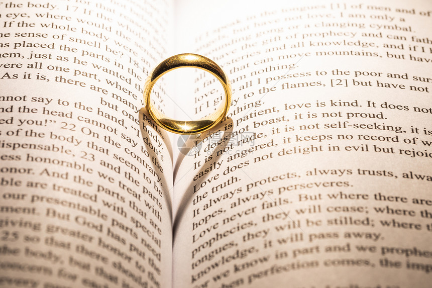 个金色的结婚戒指神圣的圣经书上与心形的阴影圣经书上的金色结婚戒指图片