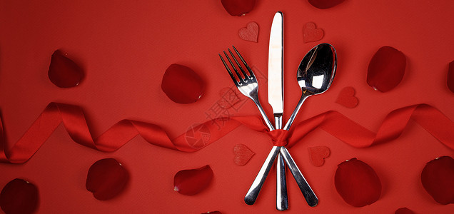 餐具套系丝带玫瑰花瓣心红色背景情人节浪漫晚餐的浪漫的晚餐图片