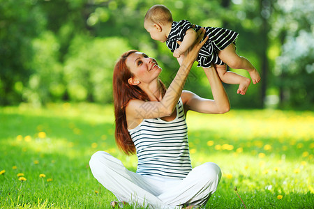 快乐的母女夏天公园的青草上母亲女儿绿草地上图片