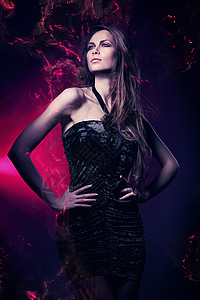 穿着黑色连衣裙的性感女人穿着紫罗兰色的灯背景图片