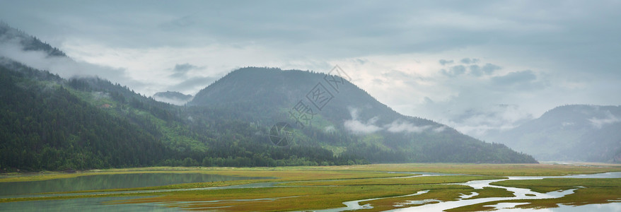 平静的景色加大的山湖旁边,岩石平静的水中反射高清图片