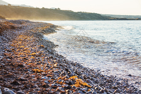 日落时海边的鹅卵石海滩图片