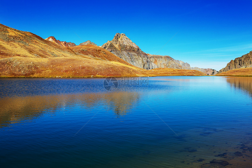 平静的景色山湖边,岩石平静的水中反射图片