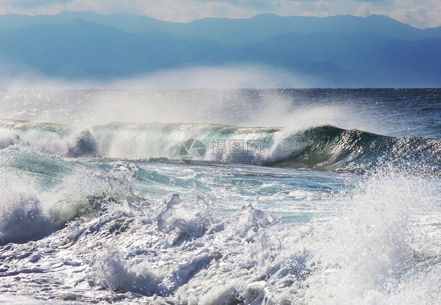 海滩上的蓝色波浪模糊背景阳光斑点戏剧的自然背景图片