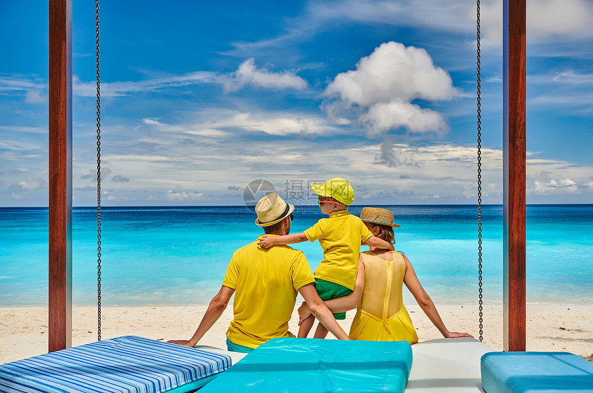 家庭美丽的娇小的Anse海滩,穿着黄色衣服的年轻夫妇三岁的蹒跚学步的男孩马赛尔的暑假图片