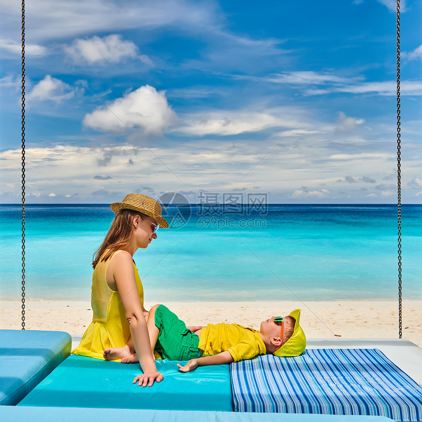 家庭美丽的娇小的Anse海滩,年轻的女人穿着黄色三岁的蹒跚学步的男孩马赛尔的暑假图片