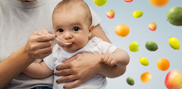 孩子,饮食食物的密切的母亲与勺子喂养小婴儿的水果背景用勺子喂小宝宝来亲近妈妈背景图片