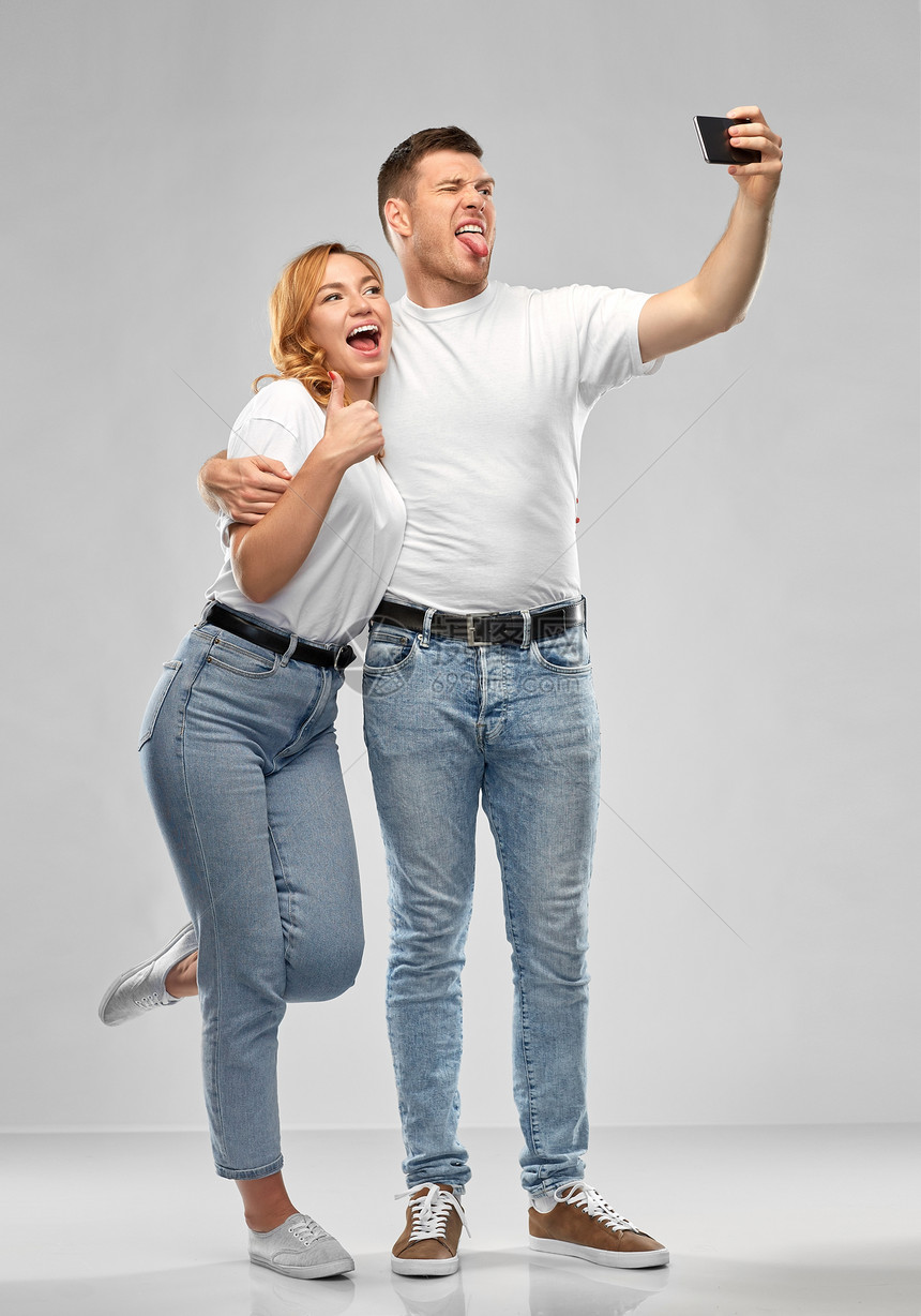 关系,技术人的幸福的夫妇白色T恤拍摄自拍智能手机灰色背景穿着白色T恤自拍的幸福夫妇图片